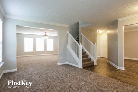 the living room and entryway of an empty house