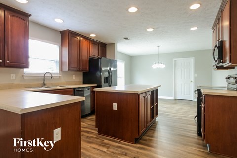 an open kitchen with wooden cabinets and white counter tops