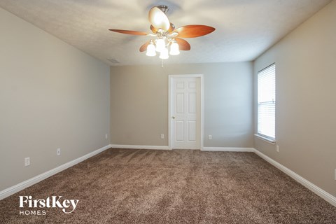 a bedroom with carpet and a ceiling fan