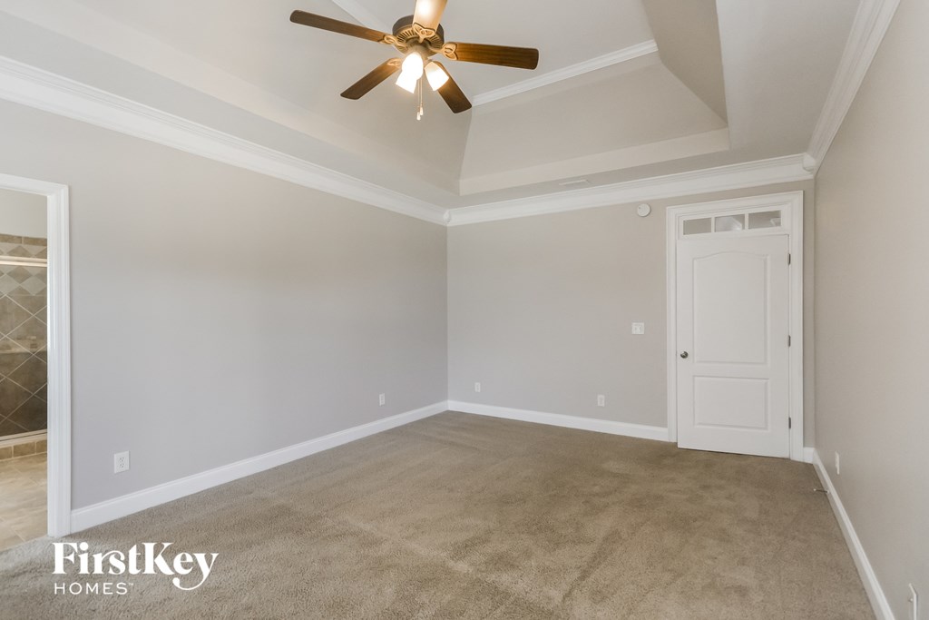 the living room of an empty home with a ceiling fan
