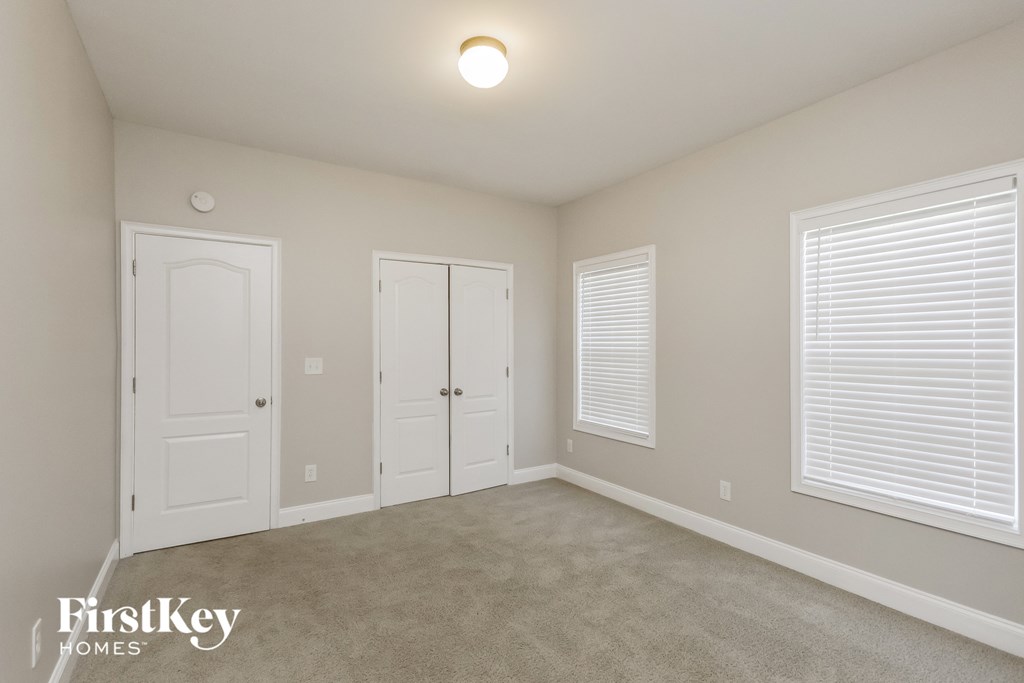a bedroom with two doors and a carpeted floor