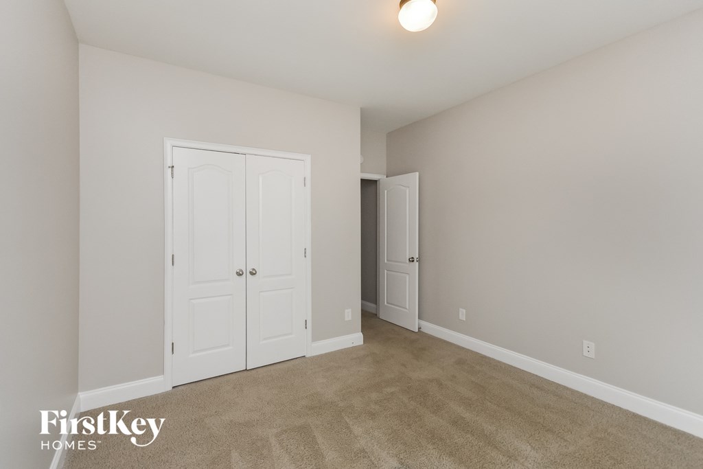 a bedroom with two closets and a carpeted floor