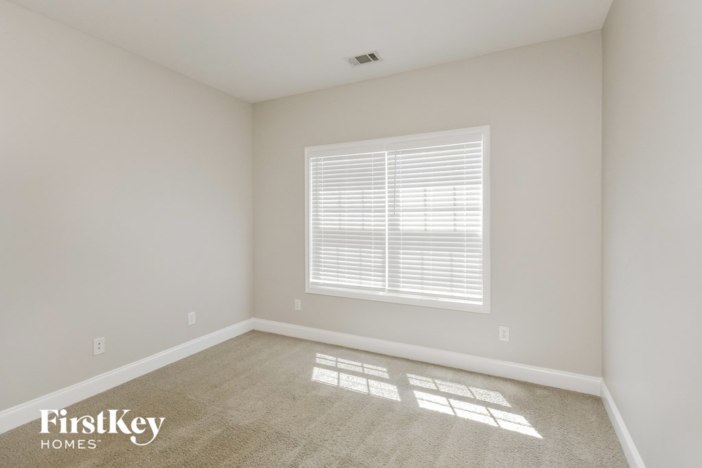 the living room of a new home with white walls and a window