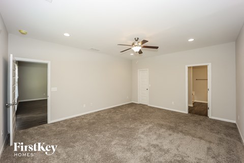 a living room with carpet and a ceiling fan