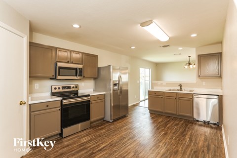 A kitchen with wooden floors and stainless steel appliances.