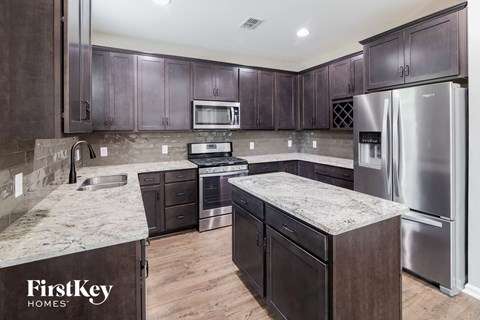 a kitchen with stainless steel appliances and marble counter tops