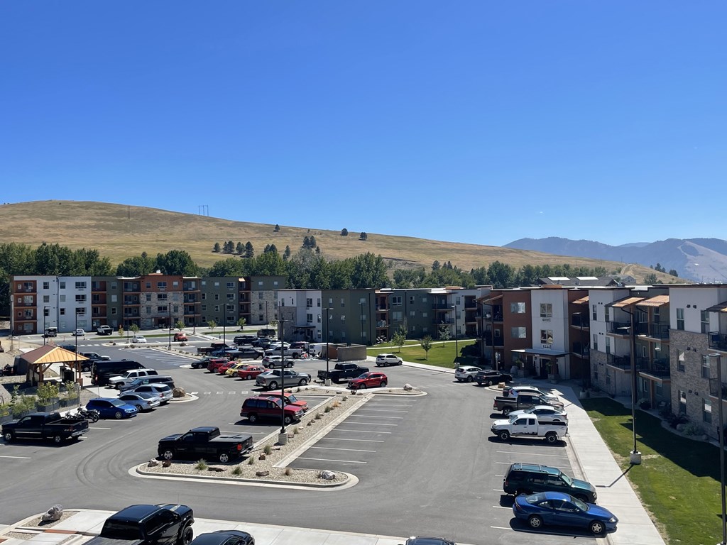 A parking lot with cars and a mountain in the background.