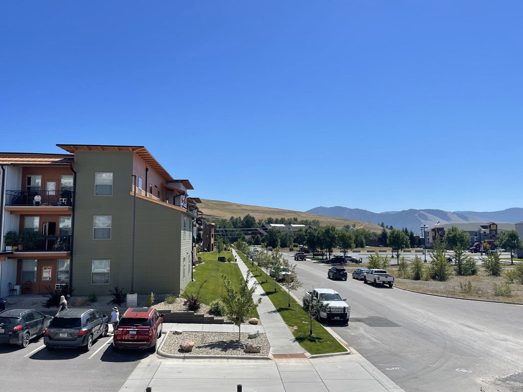 A street view of a residential area with cars parked on the side of the road.