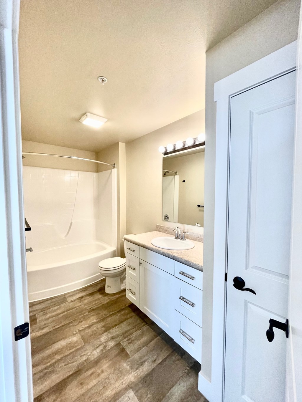 A white bathroom with a sink, toilet, and bathtub.
