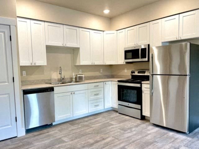 a kitchen with white cabinets and stainless steel appliances