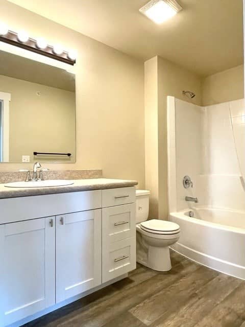 A white bathroom with a sink, toilet, and bathtub.