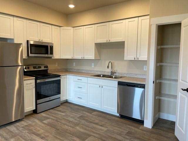 A kitchen with white cabinets and stainless steel appliances.
