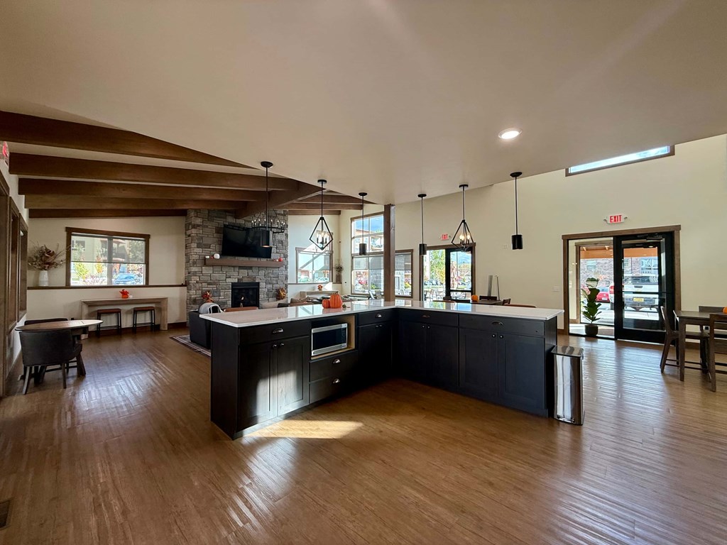 A spacious kitchen with dark wood floors and a large island.