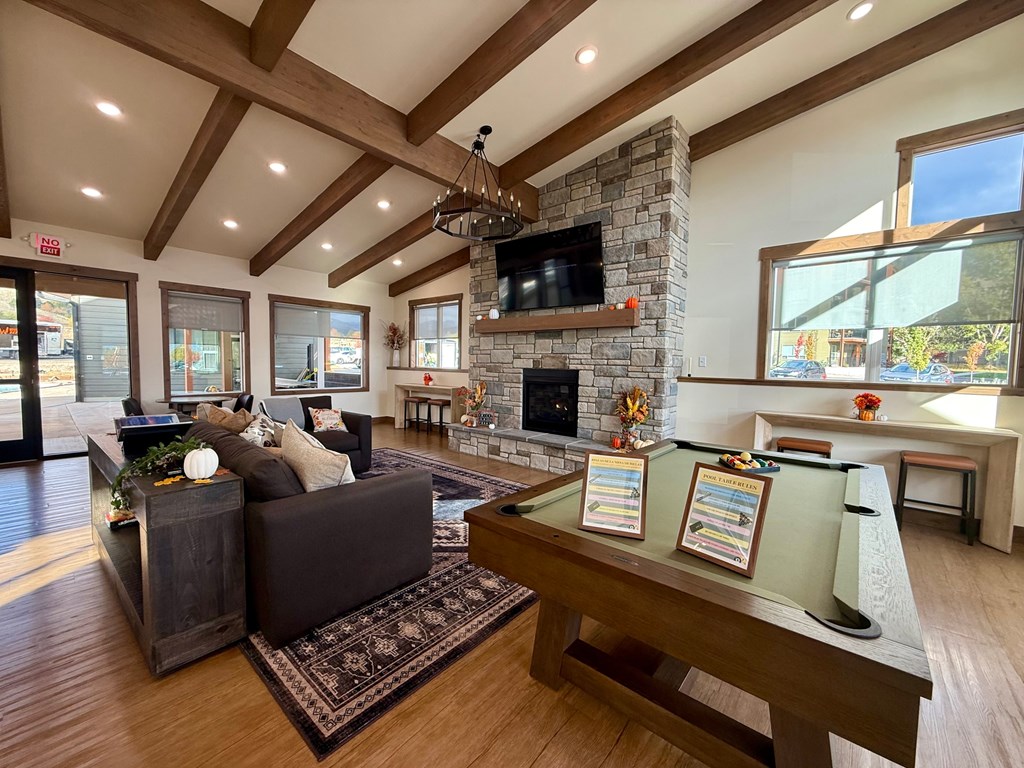 A modern living room with a pool table and a fireplace.