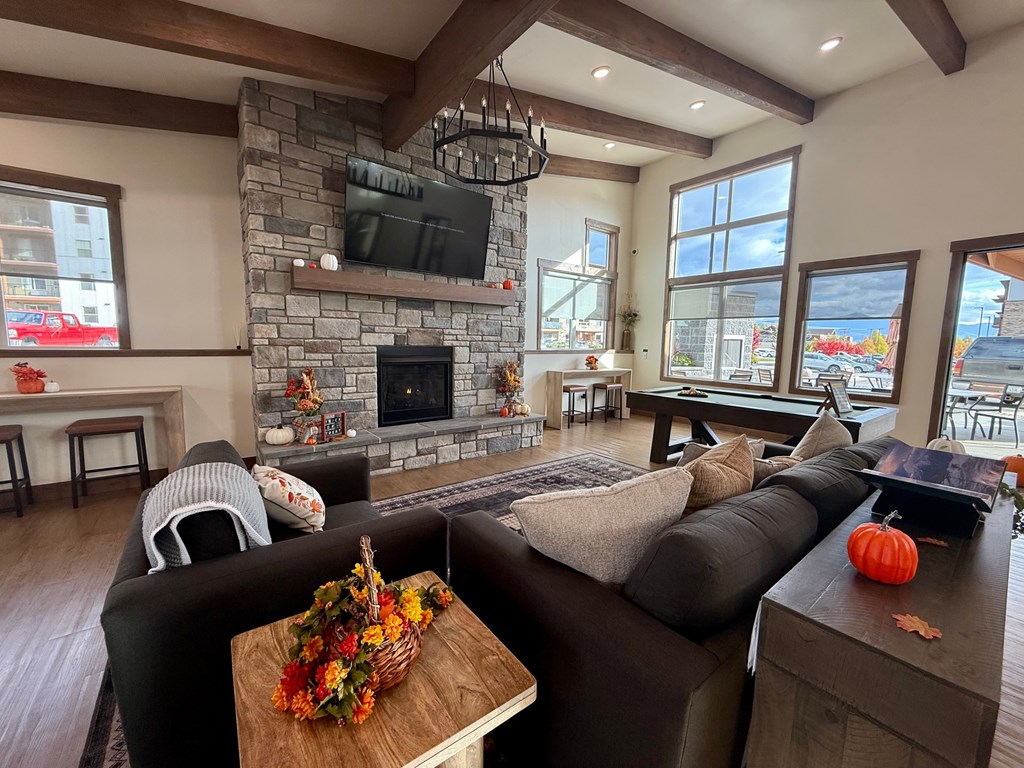 A living room with a fireplace and a TV mounted above it.
