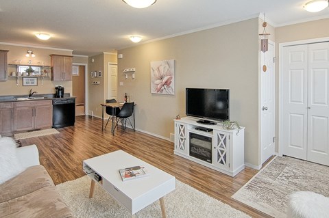 A living room with a white coffee table and a television on a stand.