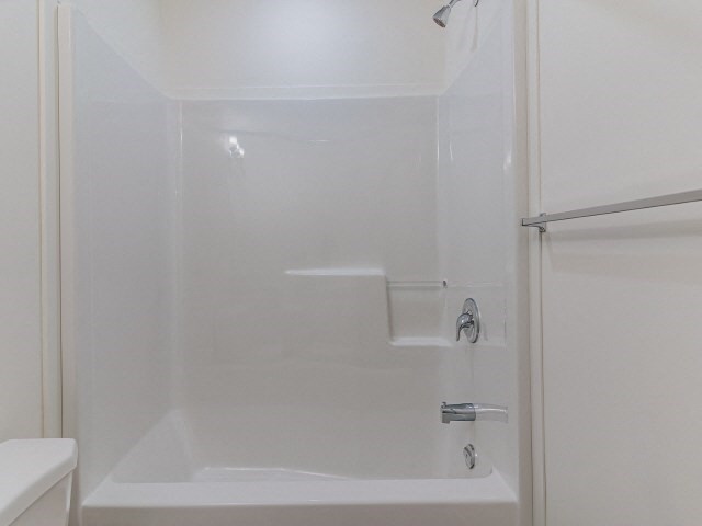 a white bathroom with a shower and a sink