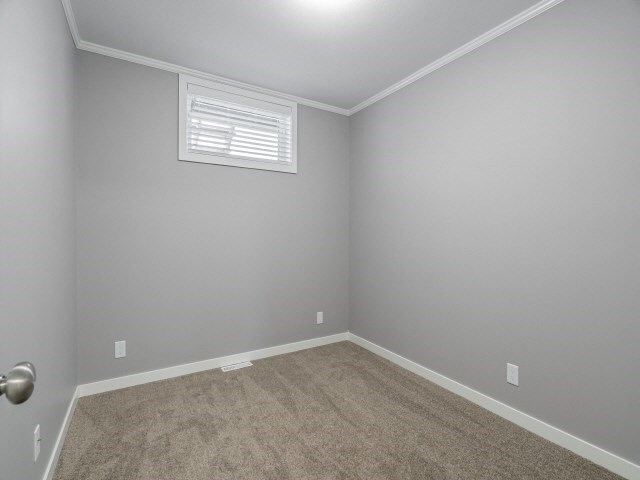 an empty room with gray walls and a window