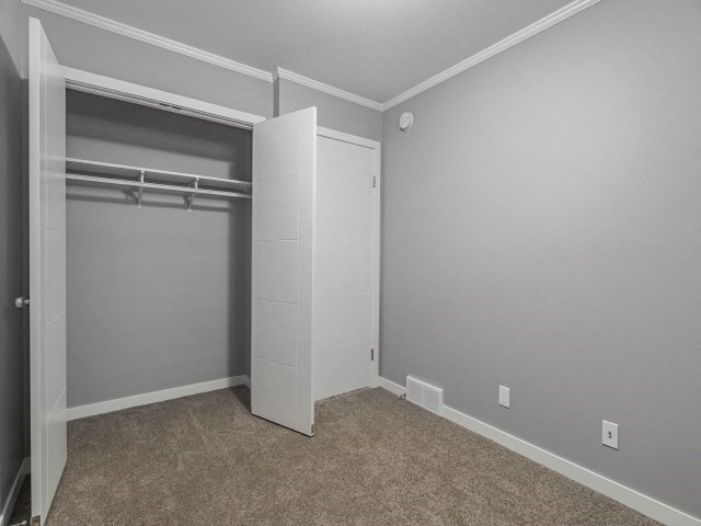 an empty bedroom with a closet and a white door