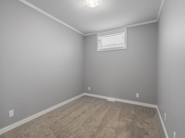 an empty room with gray walls and a window