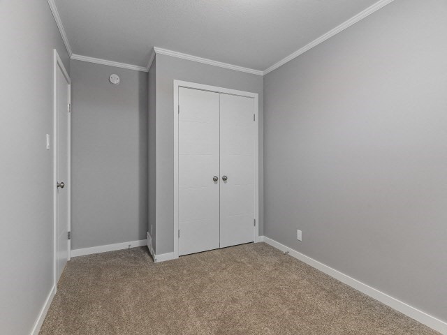 an empty bedroom with a closet and a door