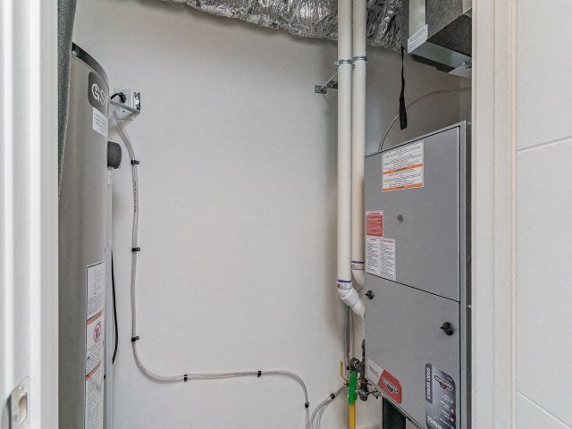 a white wall with a refrigerator and pipes