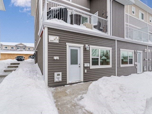 a house with a porch and a white door in the snow