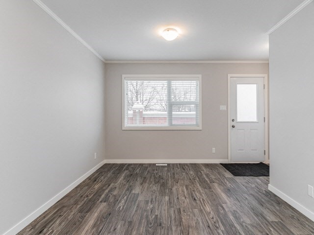 an empty living room with a window and a door