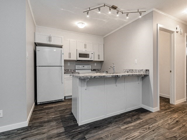 a white kitchen with a counter top and a refrigerator