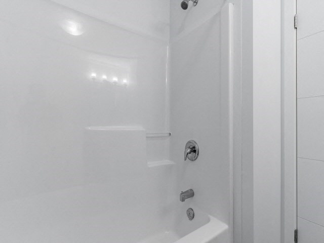 a white bathroom with a shower and a tub