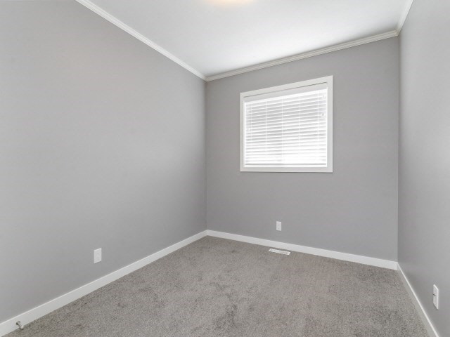 an empty room with a window and carpet