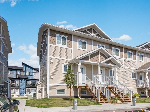 a tan house with stairs in front of a street