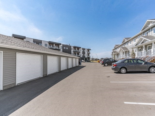a parking lot with cars parked in front of houses