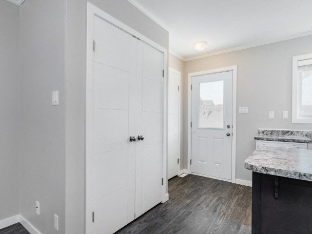 the living room and entryway of a house with white doors