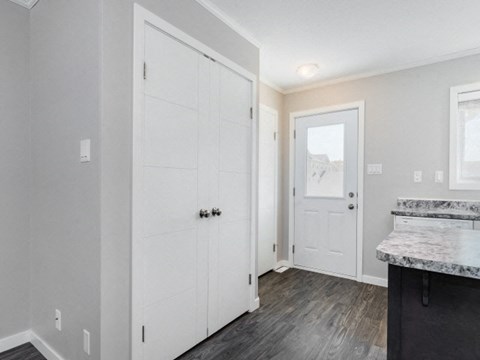 the living room and entryway of a house with white doors