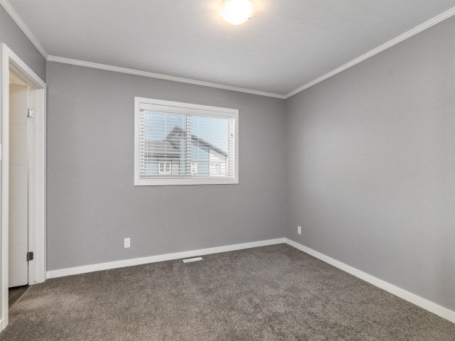 an empty room with a window and carpet