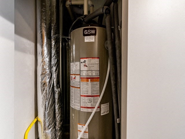 a gas water heater in the corner of a wall