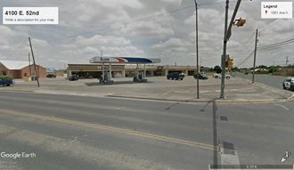 a gas station at the intersection of a street and a building