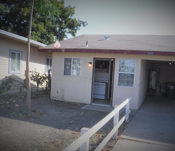 a white house with a porch and a white fence