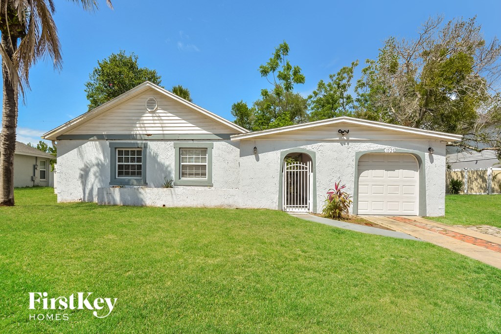 a white house with a lawn and a white garage door