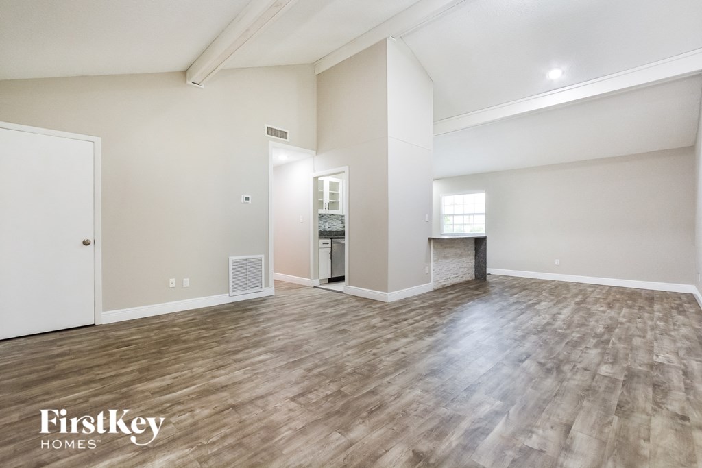 the living room and dining room with wood flooring and a fireplace