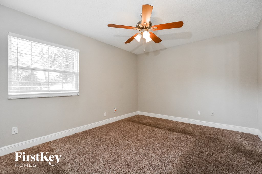 the living room of an empty house with a ceiling fan