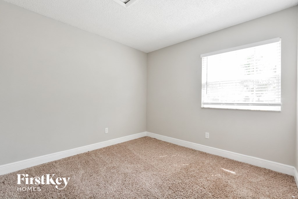 a bedroom with carpet and a window