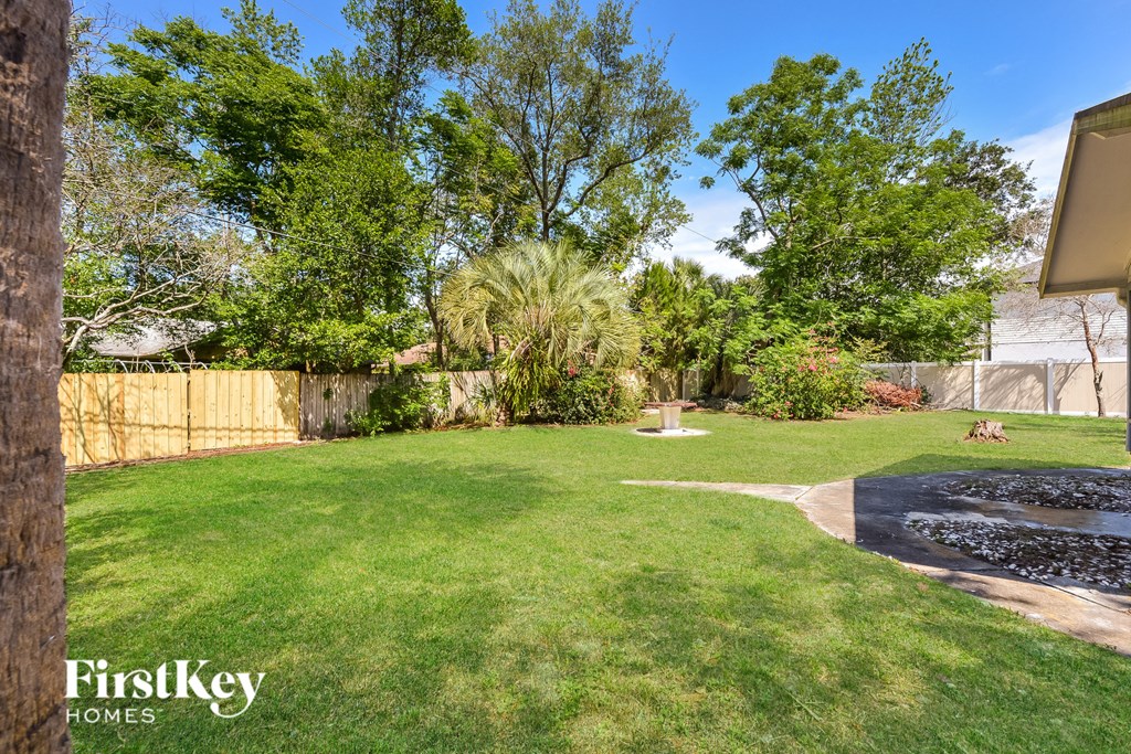 a backyard with a grass lawn and a fire pit
