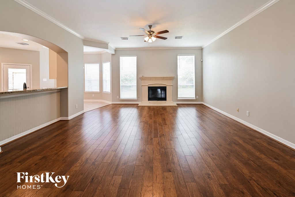 an empty living room with wood floors and a fireplace