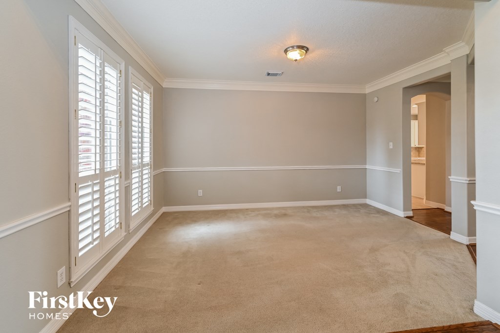 a living room with a carpeted floor and large windows
