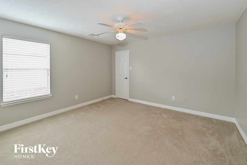 a bedroom with a ceiling fan and a window