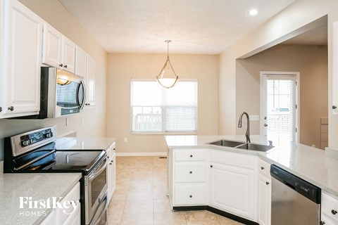A kitchen with white cabinets and a black stove top oven.