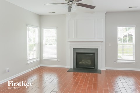 a living room with a fireplace and a ceiling fan