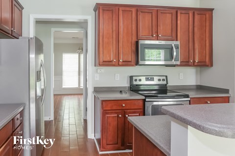 a kitchen with wooden cabinets and a stove and a microwave